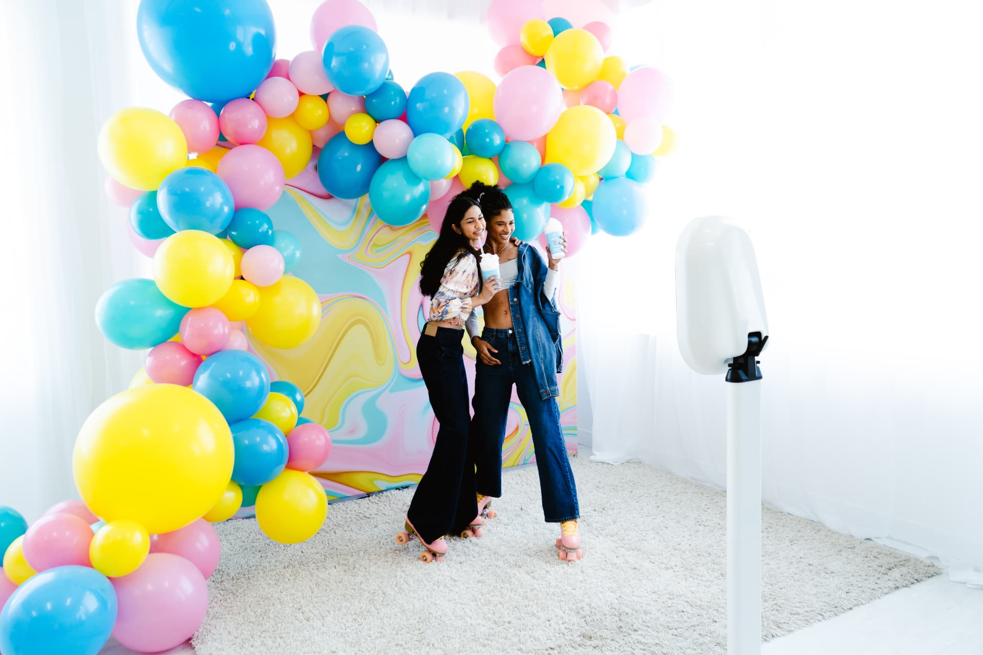 Guests posing at the open-air booth in front of a pastel balloon arch