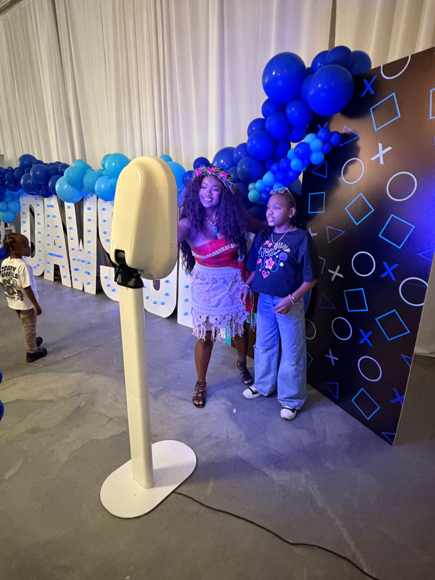 Moana character and guests at a gaming themed birthday photo booth setup