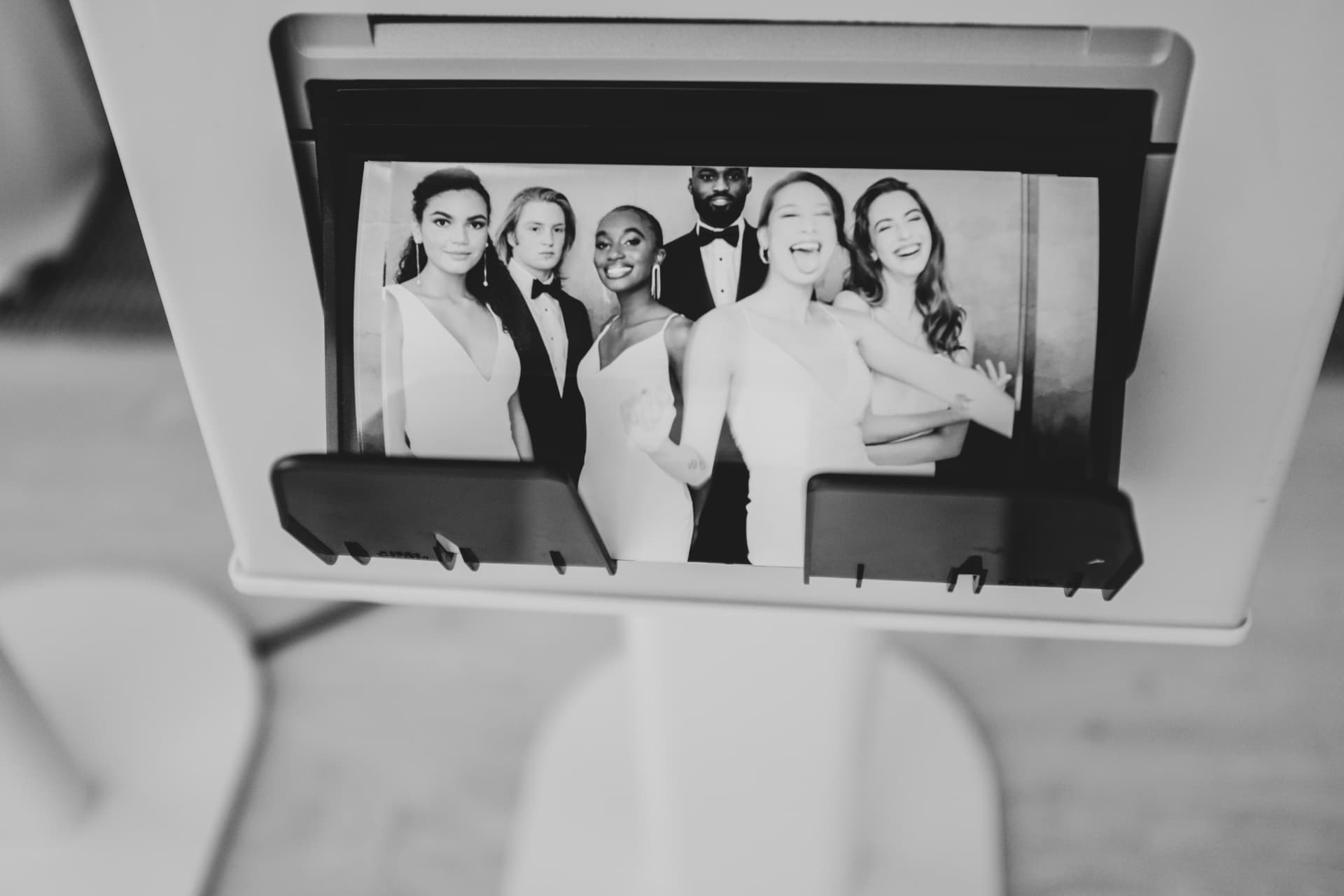 Photo booth printer delivering an instant black-and-white group print