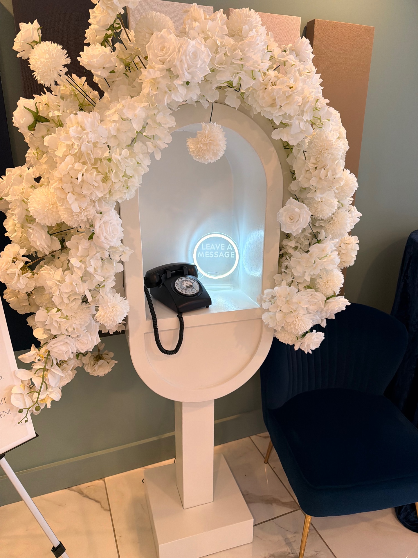 Close view of the floral audio guestbook arch with neon Leave A Message sign