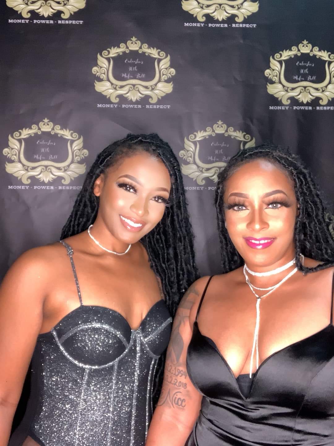 Two guests posing at a Mafia Ball themed photo booth